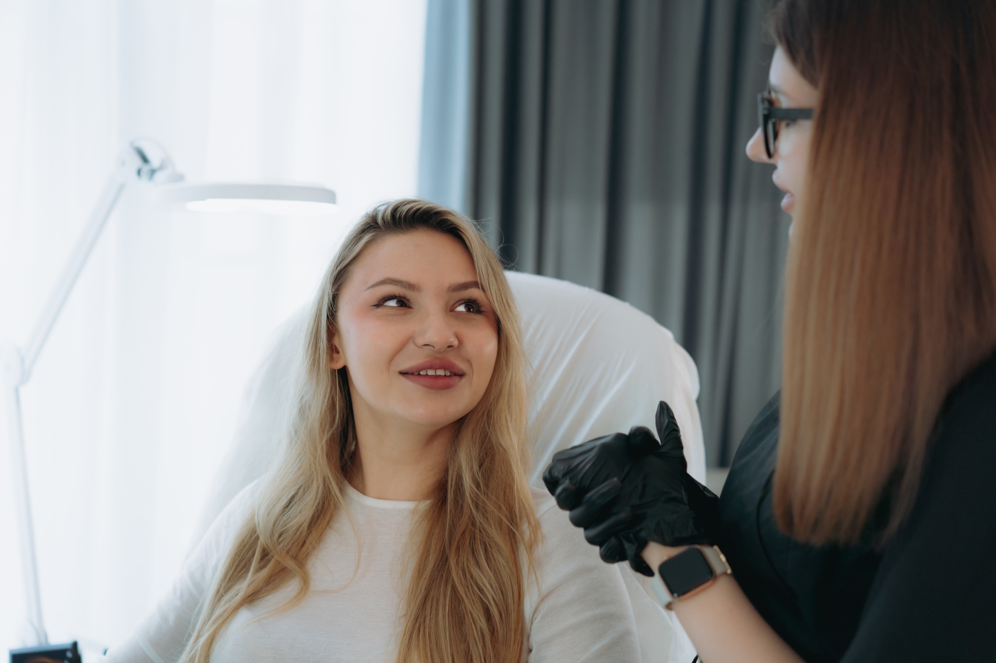 woman before facian rejuvenation injection at aesthetic clinic . Doctor explains procedure