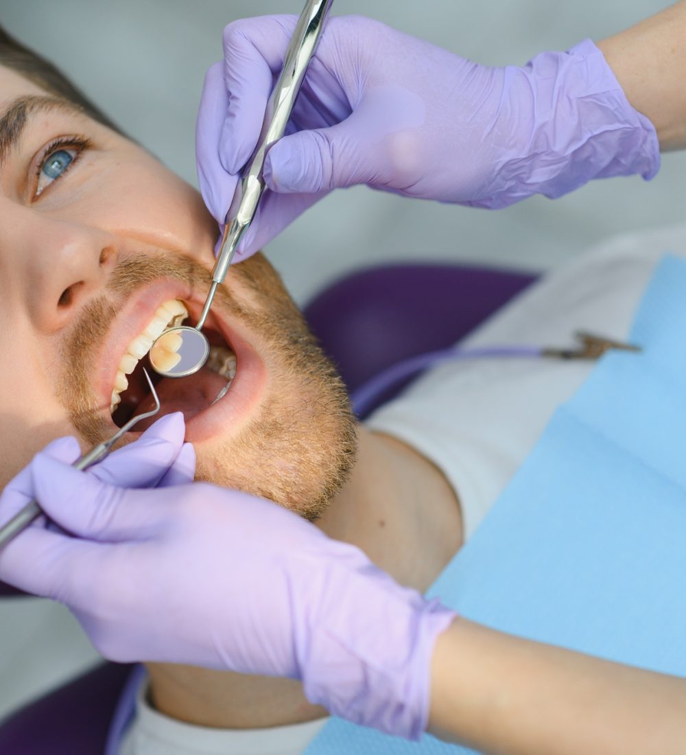 Periodontal Services. Closeup Shot Of Smiling Man Getting Treatment In Stomatologic Clinic