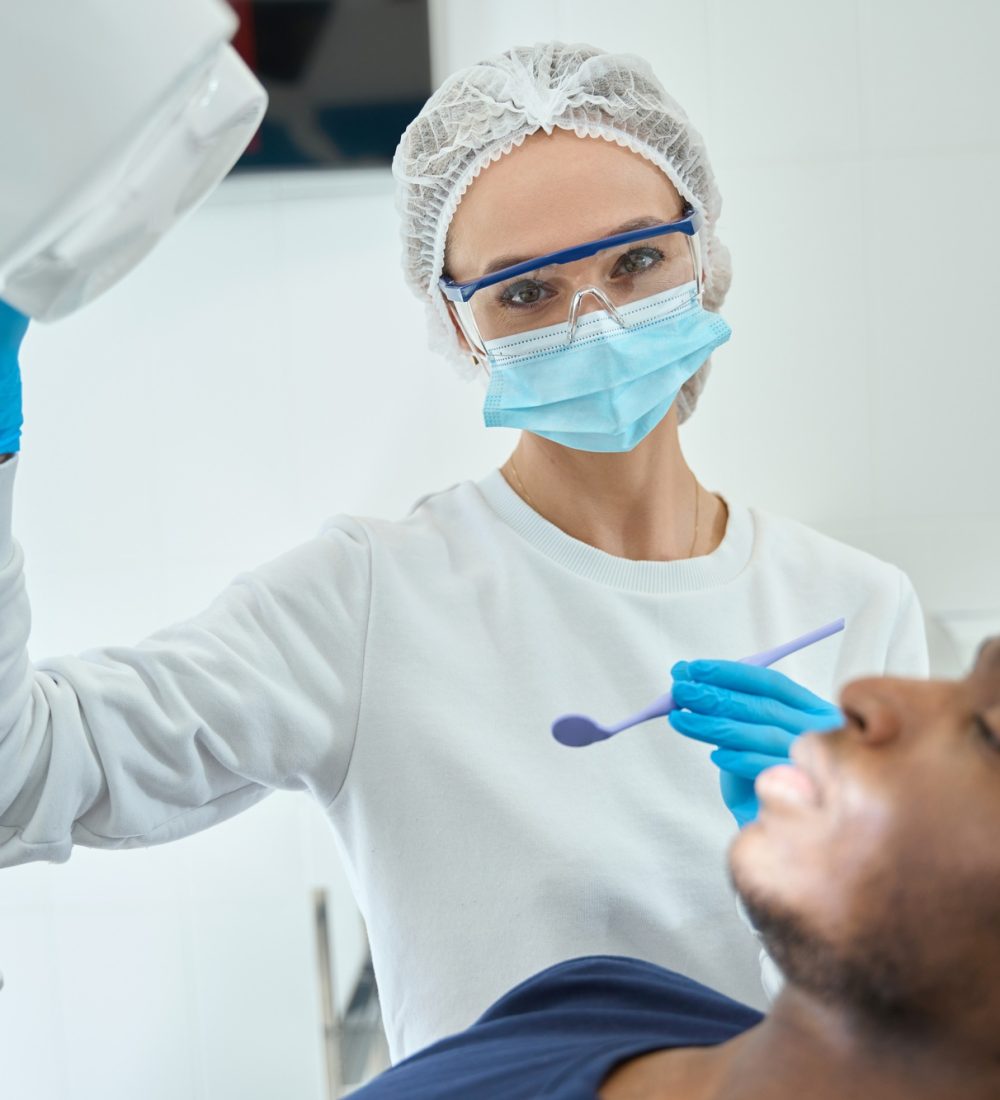 Woman doctor adjusting equipment in the dentistry